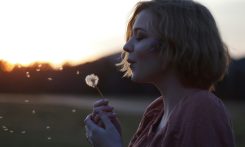 woman blowing dandelion flower selective focus photography