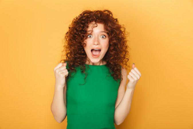 a woman in a green dress making a funny face